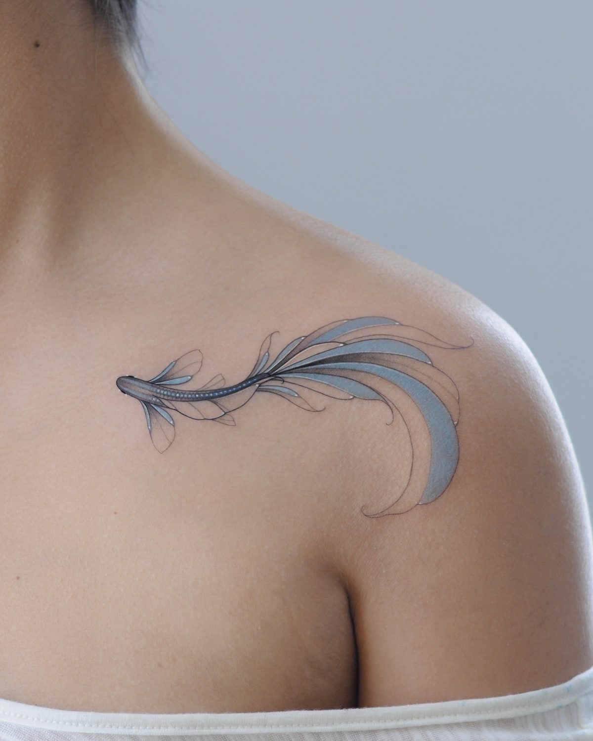 Colourful fish tattoo on a shoulder by Ink District Amsterdam