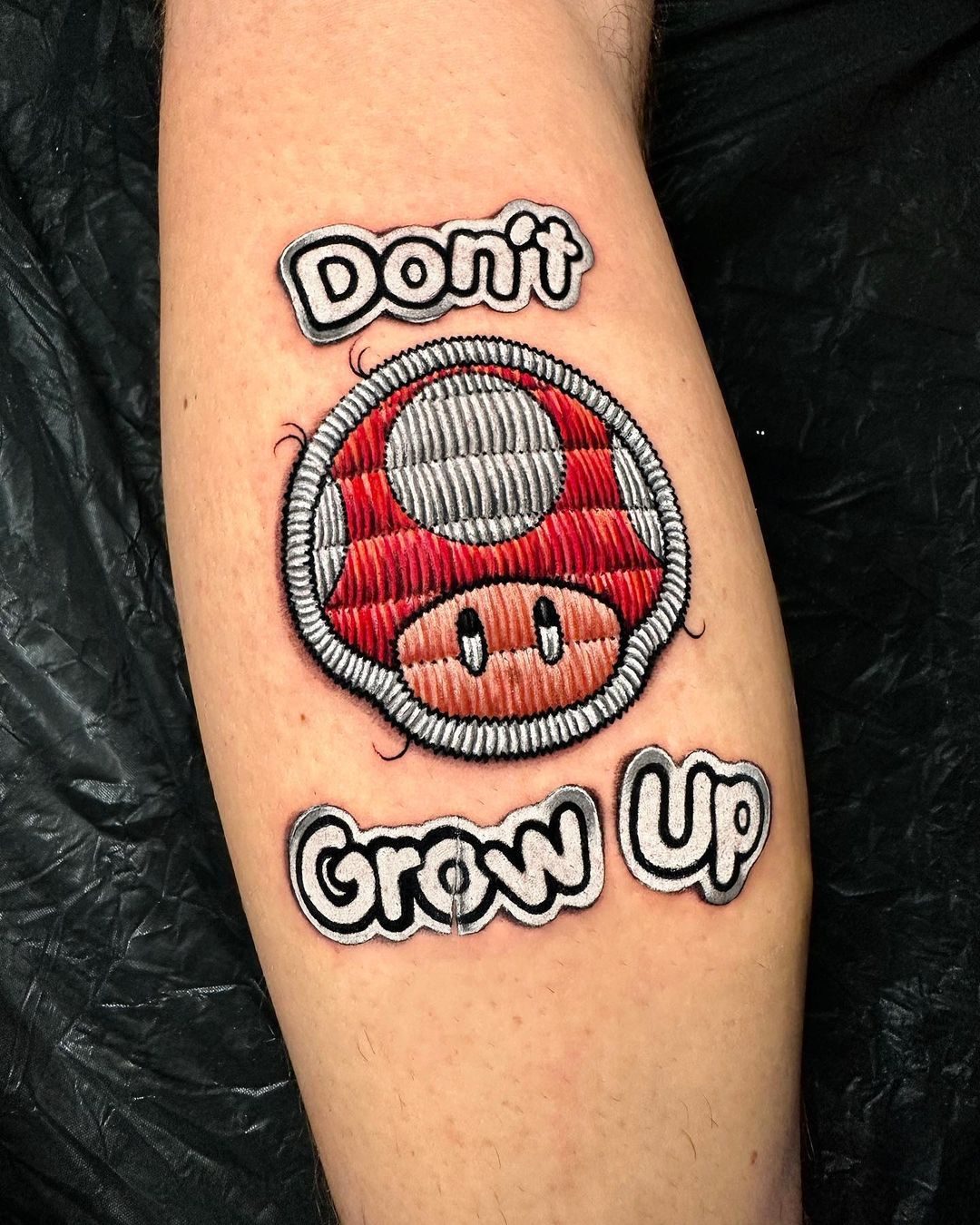 Colour patch-style lettering tattoo by Ink District Amsterdam