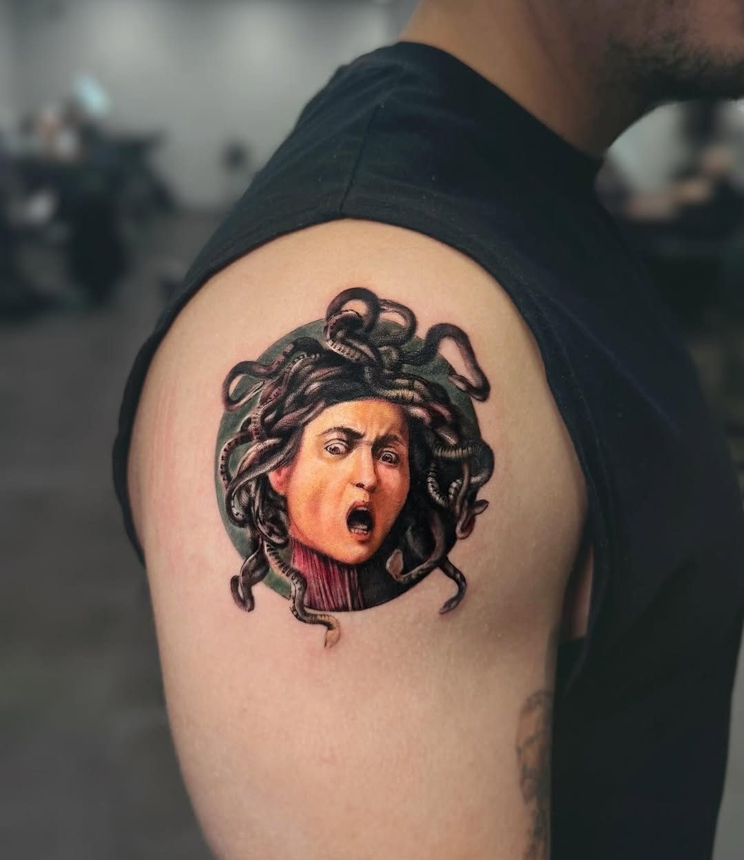 Colour Medusa tattoo on an upper arm by Ink District Amsterdam